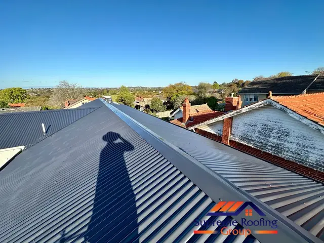 Bluestone colour coating being applied to a corrugated metal roof in Brighton