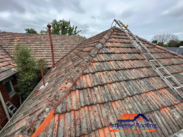Weathered terracotta hip and ridge capping before roof repair in Carnegie