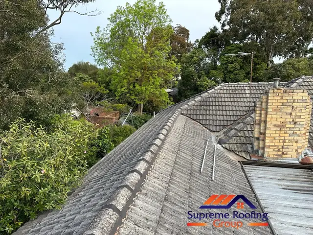 Ridge and hip rebedding work underway on a cement tile roof in Doncaster