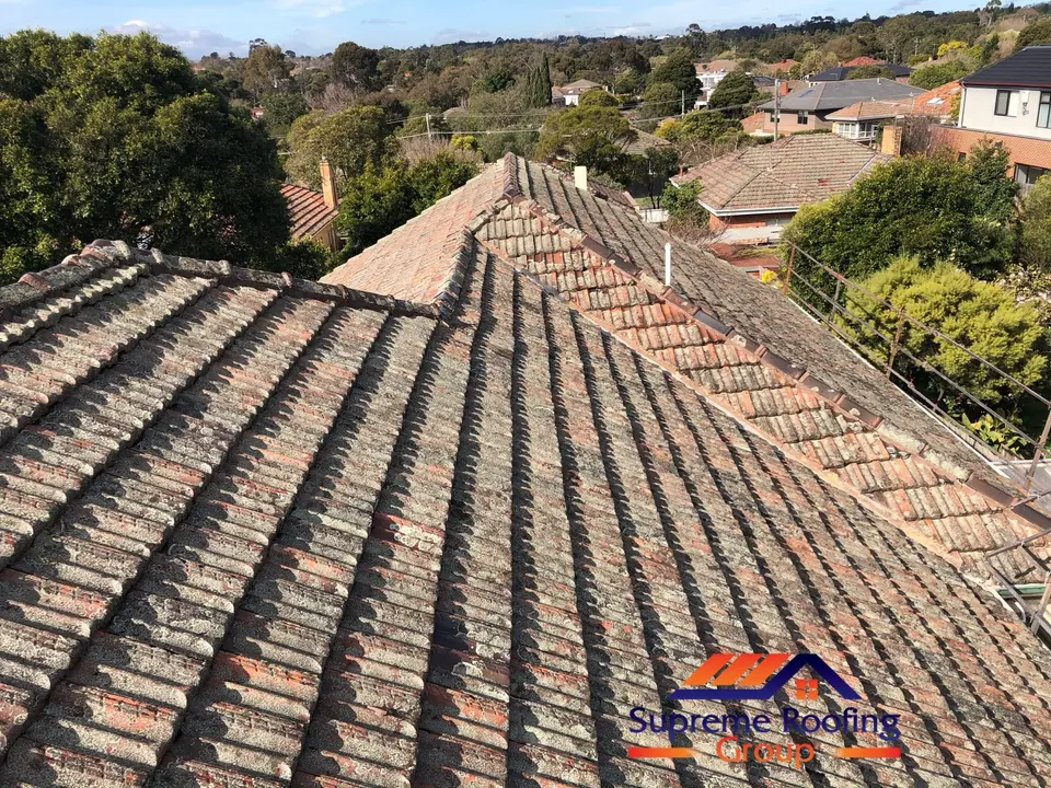Weathered terracotta roof before pressure cleaning and repairs in Kew