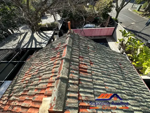 Heavy surface buildup on terracotta roof tiles before pressure cleaning in St Kilda