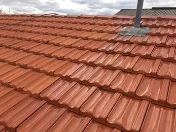 Terracotta tiled roof ridge caps inspected for rebedding and repointing