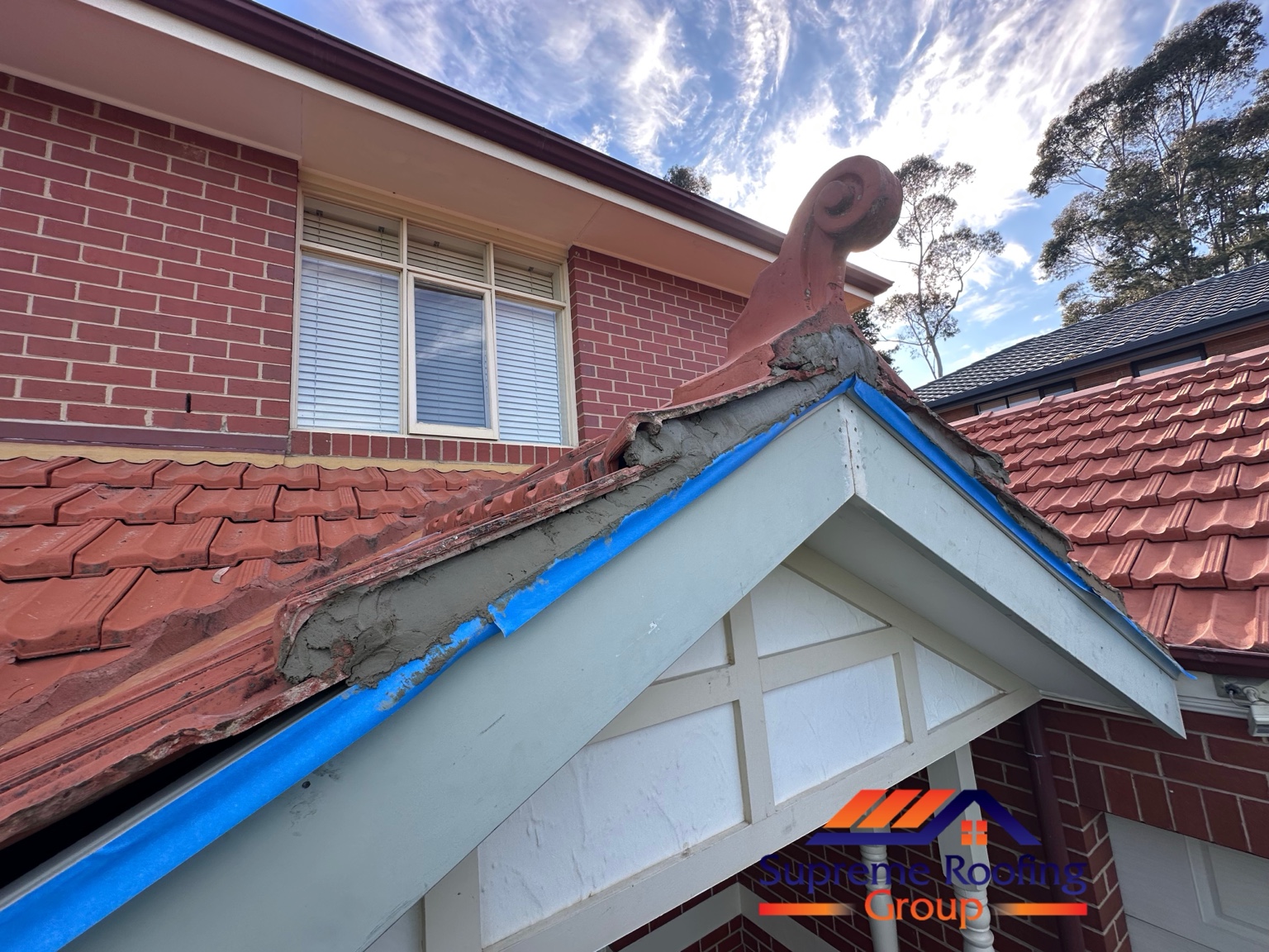 Grey mortar bedding along a Diamond Creek terracotta roof gable before the pointing finish