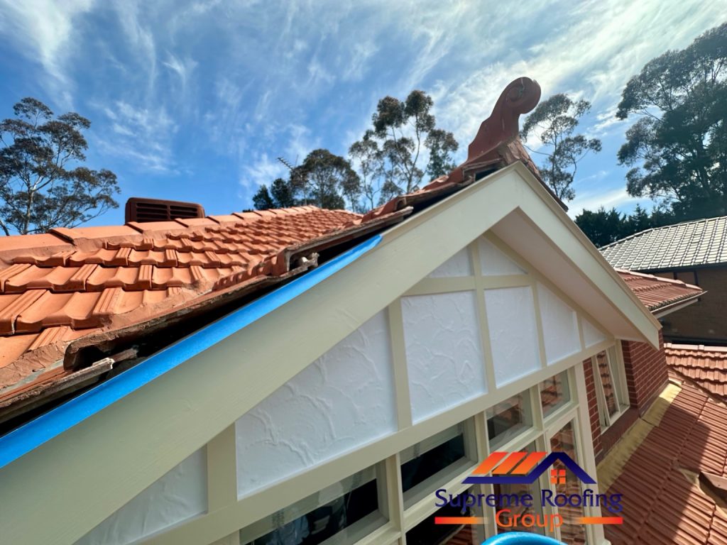 Terracotta roof gable with exposed bedding gaps and blue masking tape before finishing in Diamond Creek