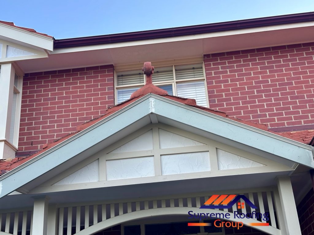 Repointed smaller gable and decorative terracotta finial above the entrance