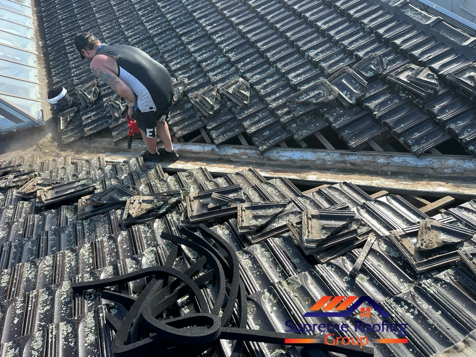 Lifted roof tiles exposing the valley during storm-seal preparation in Donvale